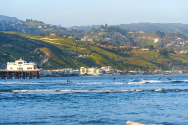 Malibu, California - 21 Nisan 2024: Malibu Rıhtımı Sörfçülerle Yeşil Tepeler