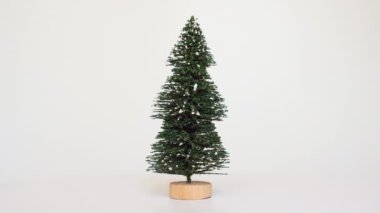 Gerçekçi minyatür Noel ağacı. Beyaz bir pikapta, ahşap bir tabanda yeşil yaprakları var..