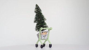 Minyatür bir Noel ağacı taşıyan bayram temalı bir alışveriş arabasının dönüş videosu..