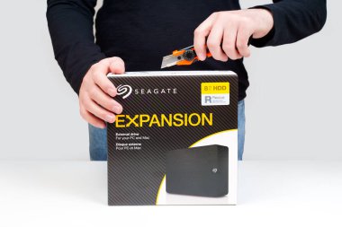 Kyiv, Ukraine - October 23, 2024: Cutting Open Seagate Expansion External HDD Package clipart