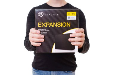 Kyiv, Ukraine - October 23, 2024: Person Holding Seagate Expansion 8TB Hard Drive Packaging clipart