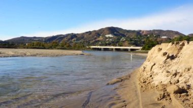 Malibu nehir kenarının manzarası. Arka planda köprü ve tepeler var..