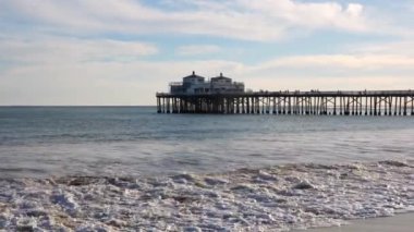 Malibu, California - 29 Kasım 2024 'te dalgalar kıyıya vuruyor ve arka planda Malibu iskelesi var..