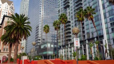 Los Angeles, Kaliforniya - 4 Aralık 2024: Pershing Meydanı 'nda Los Angeles mimarisi sergilenen, palmiye ağaçlarıyla çevrelenmiş Gaz Şirketi Kulesi ve ABD Bank Tower dikey görünümü.