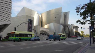 Los Angeles, Kaliforniya - 4 Aralık 2024: Walt Disney Konser Salonu önündeki trafik ve yayaların görüntüsü, Los Angeles 'taki çarpıcı mimarisini gözler önüne seriyor.