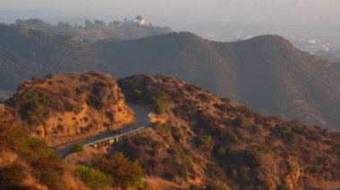 Runyon Canyon 'dan Los Angeles' ın sisli manzarası. Atmosferik koşullar altında yemyeşil yamaçlar ve yerleşim alanları var..