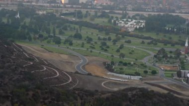 Hollywood Hills 'teki Forest Lawn Mezarlığı' nın 180 derecelik panoramik manzarası. Geniş çimenleri, dolambaçlı yolları ve sakin çevreyi aydınlatıyor..