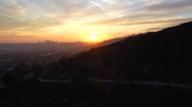 Gün batımının çarpıcı manzarası Runyon Kanyonu 'ndan Los Angeles' ın gökyüzünü aydınlatıyor, kentsel manzarayı ve doğal güzelliği vurguluyor..