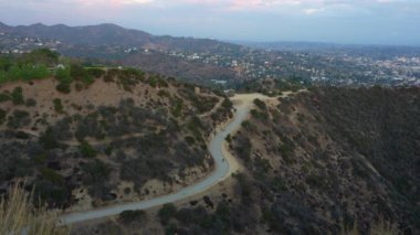 Runyon Kanyonu 'nda güzel bir günbatımında küçük figürlerin dolambaçlı patika boyunca yürüdüğü manzara..