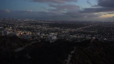 Çarpıcı gece manzarası Los Angeles 'ın aydınlık ufuk çizgisini yakalıyor şehrin ışıkları Runyon Kanyonu' nun karanlık gökyüzüne doğru parıldıyor..