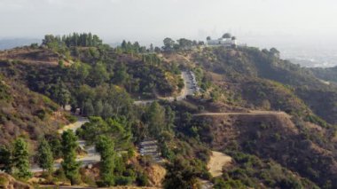 Los Angeles şehrine bakan Griffith Gözlemevi 'ne giden virajlı yollar ve yürüyüş yolları manzaralı..