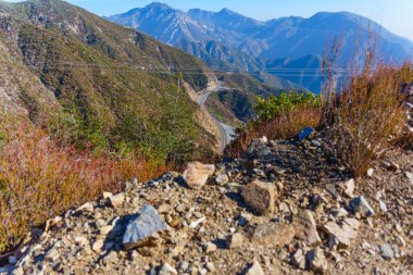 Winding Road Amidst Mountainous Terrain in Southern California clipart