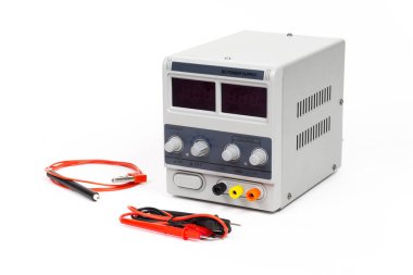 Elektro kaplama ekipmanları: DC güç kaynağı birimi, test kablosu ve elektrot tutucu temiz beyaz arka planda görüntülendi.