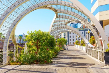 Long Beach, California - January 15, 2025: Pathway featuring decorative arches and lush greenery adjacent to the Long Beach Convention Center. clipart