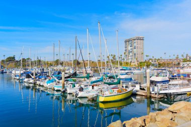 Oceanside, California - 27 Aralık 2024: Lively Marina Scene with Sailboat and Coastal High Rise Buildings