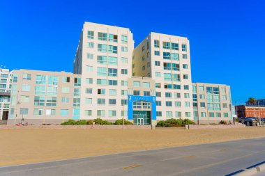 Santa Monica, California - 16 Ocak 2025: Sea Castle Apartmanları, açık mavi gökyüzü, kumlu plajlar ve canlı manzaralarla çevrili modern mimariyi gözler önüne sererek, Okyanus Önü Yürüyüşü boyunca belirgin bir şekilde durmaktadır..