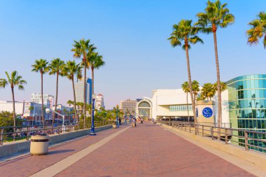 Long Beach, California - 11 Ocak 2025: Kongre merkezi ile Hyatt Regency Oteli arasında, palmiye ağaçlarıyla çevrili ve sıcak güneş ışığıyla yıkanmış.