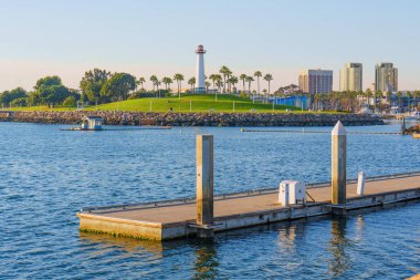 Long Beach, California - 11 Ocak 2025: Lions Lighthouse, Long Beach, Kaliforniya 'daki Shoreline Marina' da, açık gökyüzü altında palmiye ağaçları ve modern binalarla çevrili, canlı gün ışığında yakalanmış,.