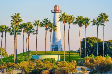 Long Beach, California - 11 Ocak 2025: Dekoratif Lions Lighthouse for Sight, Long Beach, Kaliforniya 'daki Shoreline Marina' da palmiye ağaçları arasında gün batımında parlak, güneşli bir atmosferde yakalandı..
