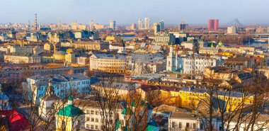 Kyiv, Ukrayna - 9 Mart 2025: Kyiv 'deki Kontraktova Meydanı yakınlarındaki canlı Podil ilçesinin panoramik manzarası, tarihi mimari, modern binalar ve açık gökyüzü altında hareketli bir kentsel manzara.