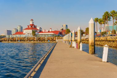 Long Beach, California - 11 Ocak 2025: Long Beach 'teki Parkers Deniz Feneri Deniz Ürünleri Restoranı' nın panoramik perspektifi, canlı renkler, palmiye ağaçları, kayalık kıyı şeridi, mavi sular ve açık gökyüzü.