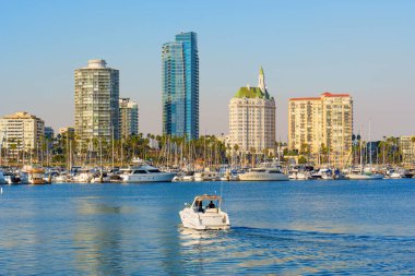 Long Beach, California - 11 Ocak 2025: Sakin sular, yelkenliler ve günbatımı ışığında parlayan modern gökdelenlerin geniş açılı bir perspektiften çekildiği Long Beach, Kaliforniya 'nın sakin manzarası.