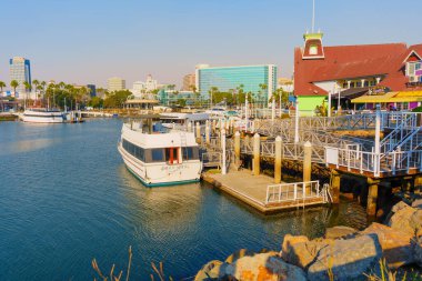 Long Beach, California - 11 Ocak 2025: Hyatt Regency oteli, marinası ve teknelerinin sergilendiği Shoreline Village 'ın geniş açılı görüntüsü, Long Beach' in canlı sahil ve deniz turu aktivitelerini vurguluyor..