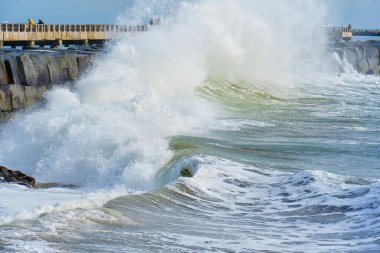 Cabrillo Sahili İskelesindeki kayalara çarpan güçlü dalgaların muhteşem manzarası dramatik beyaz su sıçramaları ve sakin bir sahil atmosferi sergiliyor..