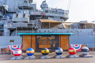 Los Angeles, California - 25 Aralık 2024: Battleship USS Iowa Müzesi önünde renkli işaretler ve bayraklarla donanma mirası ve tarihi sergilenmektedir..