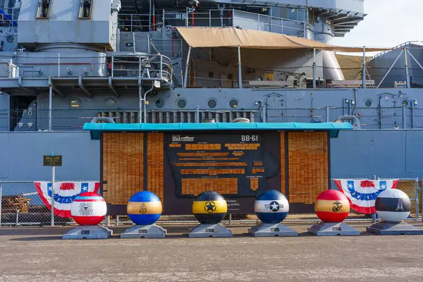 Los Angeles, Kaliforniya - 25 Aralık 2024: Los Angeles Limanı 'nın arka planında plaketlerin ve USS Iowa savaş gemisinin yer aldığı USS Plankowners Recognition Board' un yakın görüntüsü.