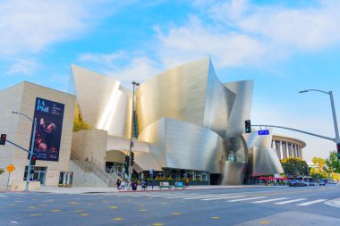 Los Angeles, Kaliforniya - 4 Aralık 2024: Walt Disney Konser Salonu 'nun metalik cephesi, arka planda mavi bir gökyüzü ile günbatımının altın ışığı altında parlar ve muhteşem mimarisini vurgular.