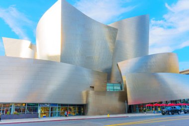 Los Angeles, Kaliforniya - 4 Aralık 2024: Los Angeles 'ta canlı mavi gökyüzüne karşı Walt Disney Konser Salonu' nun parlak gümüş dış görünüşünü gösteren geniş açı görüntüsü.