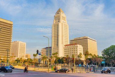 Los Angeles, Kaliforniya - 4 Aralık 2024: Los Angeles Belediyesi, palmiye ağaçları ve kentsel manzarayla çevrili açık mavi gökyüzüne karşı duruyor..