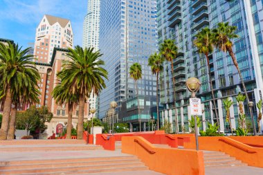 Los Angeles, Kaliforniya - 3 Aralık 2024: Pershing Meydanı 'nda canlı şehir manzarası Palmiye ağaçları, modern mimari ve Los Angeles' ta açık mavi gökyüzü altında renkli adımlar.