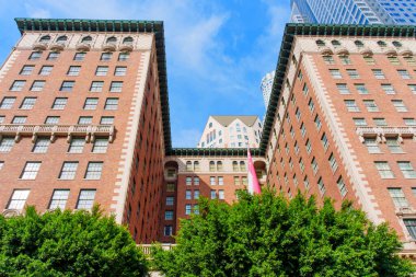 Los Angeles, Kaliforniya - 3 Aralık 2024: Los Angeles 'taki tarihi Biltmore Oteli' nin geniş açılı görüntüsü, parlak mavi gökyüzüne karşı kendine özgü mimarisini sergiliyor.