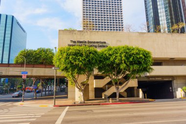 Los Angeles, California - 4 Aralık 2024: The Westin Bonaventure Hotel 'in geniş açılı çekimi Los Angeles şehir merkezindeki eşsiz mimari tasarımı ve çevresindeki yeşillikleri gözler önüne seriyor.