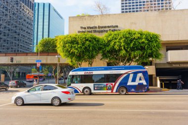 Los Angeles, Kaliforniya - 4 Aralık 2024: Los Angeles 'taki Westin Bonaventure Hotel ve DASH otobüsünün görüntüsü, şehir mimarisi ve şehir trafiğini gözler önüne seriyor.