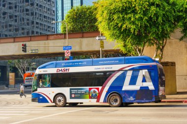 Los Angeles, Kaliforniya - 4 Aralık 2024: DASH şehir otobüsü Los Angeles şehir merkezinde işlek bir kavşakta yol alırken, modern şehir ulaşımını ve şehir yaşamını gözler önüne seriyor.