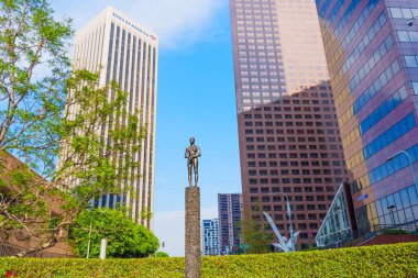 Los Angeles, Kaliforniya - 4 Aralık 2024: Robert Graham tarafından yapılan 'Kaynak Figürü' halk sanatı aydınlık bir günde Los Angeles şehir merkezindeki modern gökdelenler tarafından çerçevelendi.