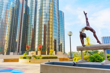 Los Angeles, Kaliforniya - 4 Aralık 2024: Gündüz vakti Los Angeles 'taki YMCA Avlusu' nda modern gökdelenlerin önünde bir kulplu atın bronz heykeli sergileniyor.