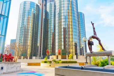 Los Angeles, Kaliforniya - 4 Aralık 2024: 1984 Olimpiyat Oyunları 'nın geniş açı görüntüsü Milton Hebald' ın YMCA Avlusu 'nda modern gökdelenlere karşı bronz bir heykel sergilemesi.