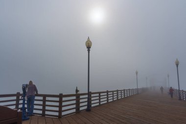 Oceanside, California - 3 Ocak 2025: Oceanside Belediye İskelesi 'nin geniş açılı manzarası sisle örtülmüş, balıkçıları ve hafta sonu sabahının keyfini çıkaran ziyaretçileri yakalıyor.