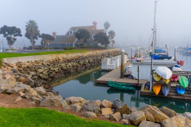 Oceanside, California - 3 Ocak 2025: Oceanside, Kaliforniya 'da sakin marina, sis, tekne ve kayalık kıyılar, yumuşak sabah ışığında geniş bir perspektifle çekildi.