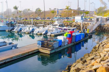 Oceanside, California - 3 Ocak 2025: Oceanside, Kaliforniya 'da sakin bir liman, sakin sulara yansıyan yumuşak sabah ışığı altında balıkçı tekneleri ve canlı çöp bidonları sergileniyor..