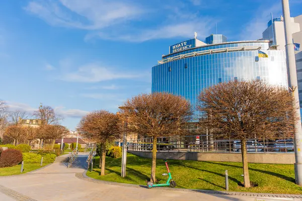 Kyiv, Ukrayna - 28 Mart 2025: Kyiv 'deki Hyatt Regency otelinin geniş açılı görüntüsü, modern mimarisini açık mavi gökyüzüne ve iyi korunmuş peyzajına karşı sergiliyor.