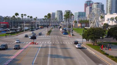 Long Beach, California - 11 Ocak 2025: Batı Shoreline Drive 'da hareketli bir sahne, yoğun bir cadde boyunca uzanan palmiye ağaçları, açık mavi gökyüzü altında trafikte gezinen araçlar, yukarıdan çekilen.