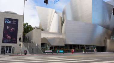 Los Angeles, California - 7 Ocak 2025: Walt Disney Konser Salonu aksiyon - motosikletçi U-turn ve aynı anda geçen kaykaycılar