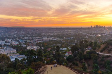 Los Angeles, California - 3 Aralık 2024: Günbatımında Los Angeles ufuk çizgisini ve çevresindeki tepeleri görmek, canlı renkler ve Runyon Canyon Park 'ından elde edilen geniş bir kentsel manzara.