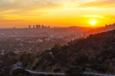 Los Angeles, Kaliforniya - 3 Aralık 2024: Günbatımında Los Angeles 'ın nefes kesici görüntüsü, Runyon Canyon Park' tan canlı turuncu ve sarı renkler sergiliyor..