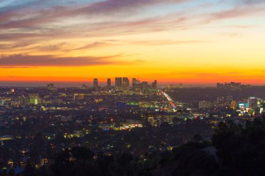 Los Angeles, Kaliforniya - 3 Aralık 2024: Runyon Canyon Park 'tan gün batımında panoramik manzara, renkli gökyüzü altında canlı renkler ve şehir ışıkları sergileniyor.